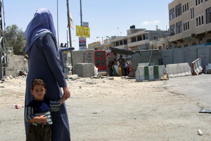 Woman and child standing in front of a checkpoint
