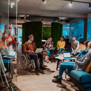 photo showing a group of employees including a person with disability in an informal meeting setting